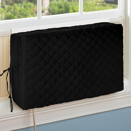 Black quilted indoor window air conditioner cover installed on a unit in a window.