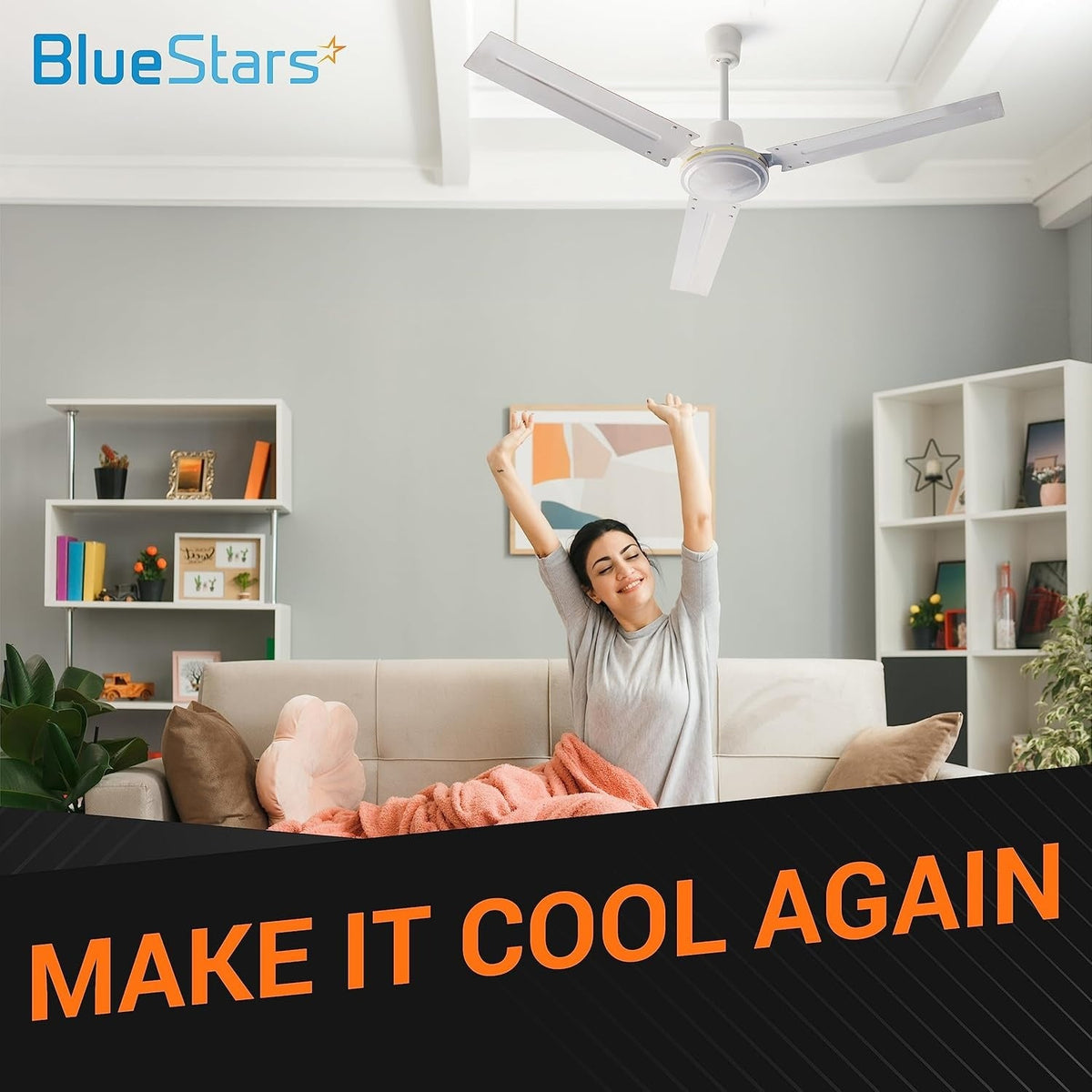 Woman relaxing on a sofa under a white ceiling fan, lifestyle image for BlueStars ceiling fan capacitor replacement.